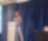 A person standing in front of a podium speaking on a microphone
