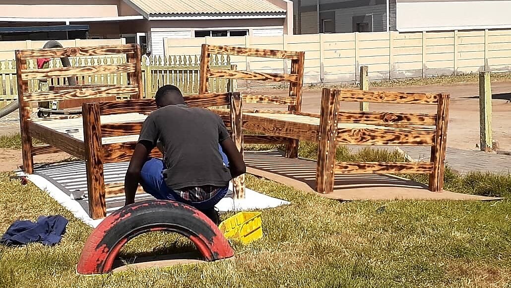 A person sitting in front of wooden bed frames